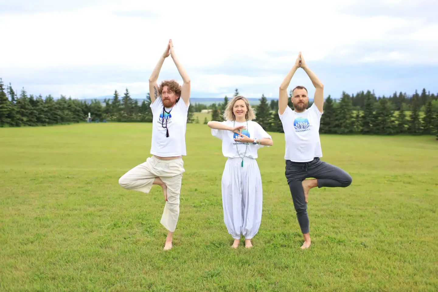 Vipassana.ca retreat team practising tree pose (vrikshasana) outdoors in Alberta