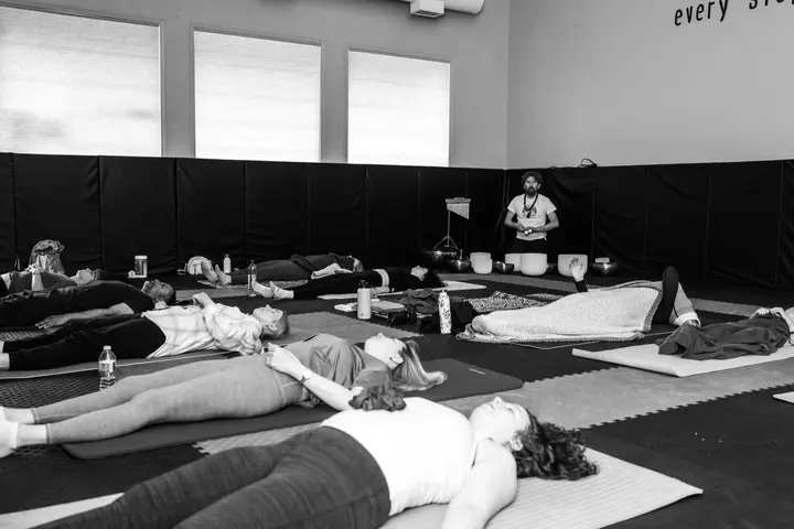 Sound bath at a Vipassana.ca event in Alberta: participants lying on mats while the facilitator plays crystal singing bowls