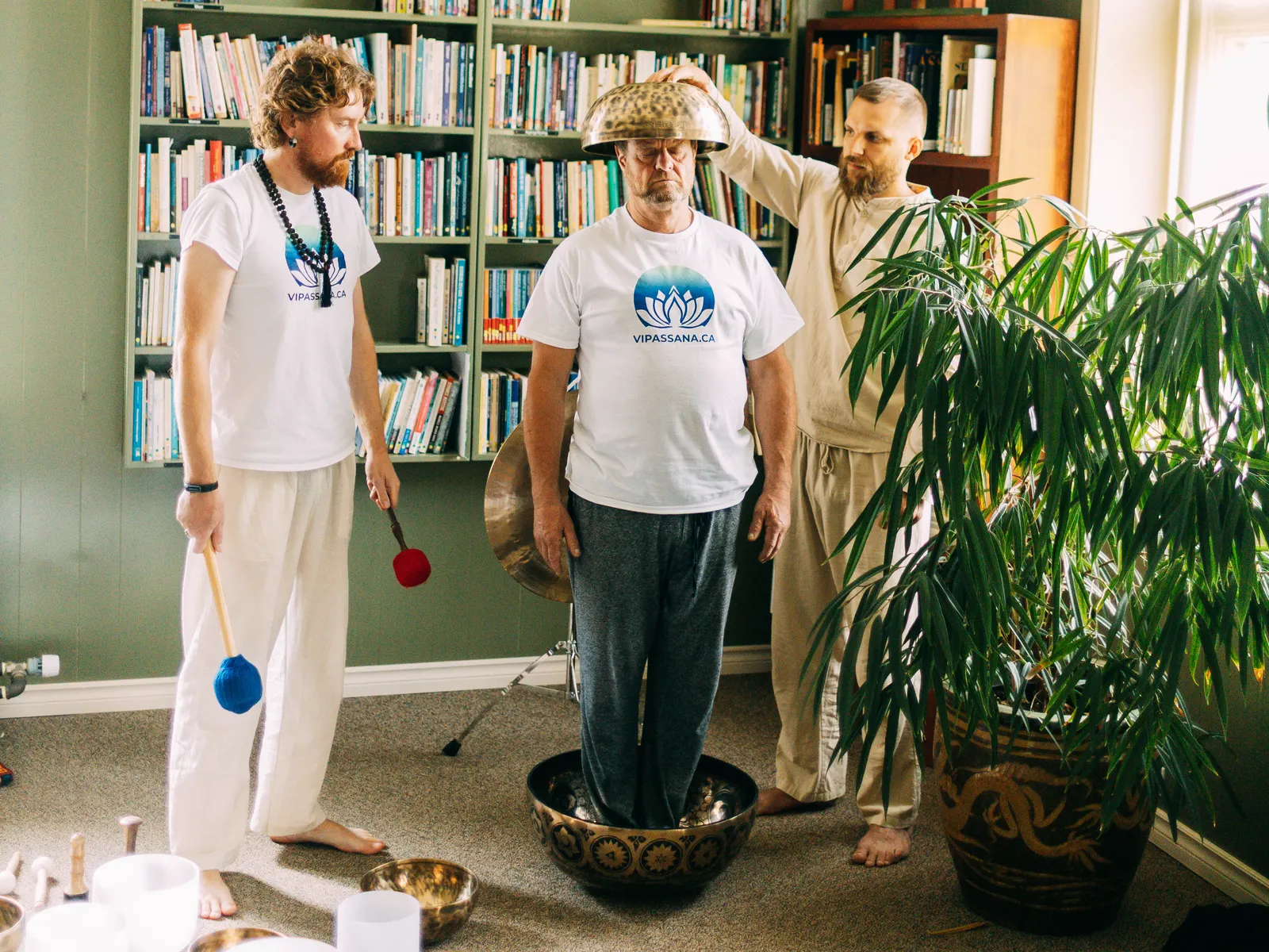 Valerii Bandurko and Artem Rusinov leading a sound bath: singing bowls played around a participant standing in a large bowl